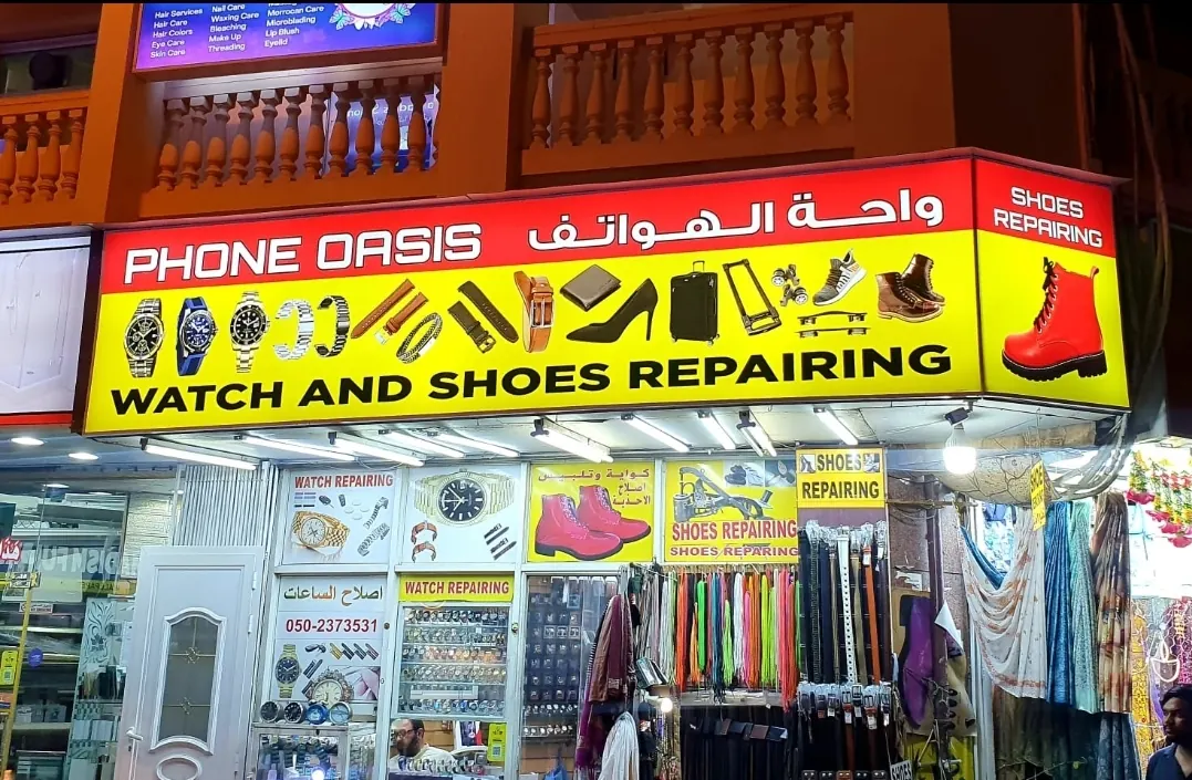 The shopfront on Al Satwa Road with the yellow Watch and Shoes Repairing sign